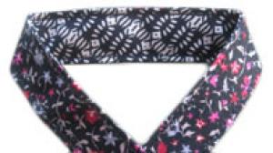 Attache-doudou fleuri et motifs géométriques beige et noir